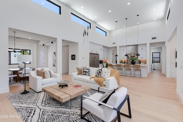 living room with baseboards, light wood-type flooring, and recessed lighting