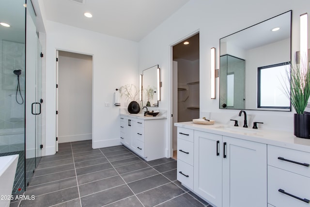 bathroom featuring recessed lighting, a sink, a shower stall, and tile patterned floors