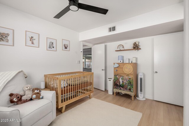 7811 N 32nd Ave, Phoenix, AZ 85051 - bedroom featuring a crib, light wood-style floors, visible vents, and ceiling fan