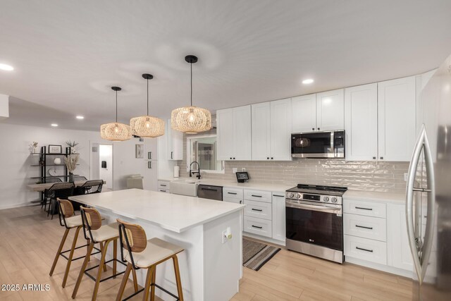 7811 N 32nd Ave, Phoenix, AZ 85051 - kitchen with a kitchen bar, light wood-style floors, appliances with stainless steel finishes, and decorative backsplash
