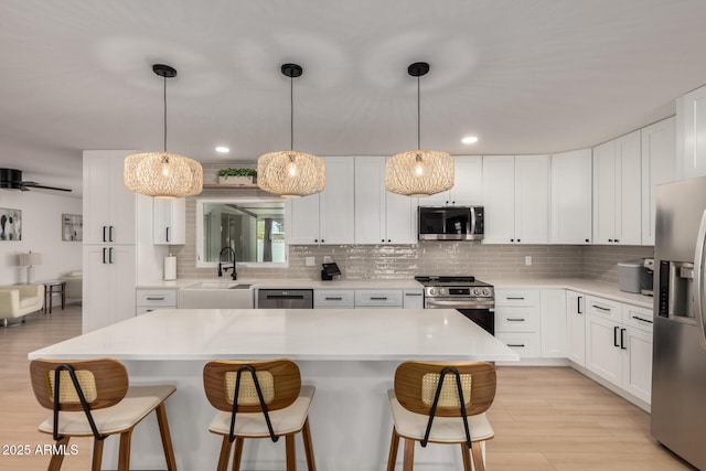 7811 N 32nd Ave, Phoenix, AZ 85051 - kitchen featuring white cabinetry, a sink, appliances with stainless steel finishes, a kitchen bar, and tasteful backsplash