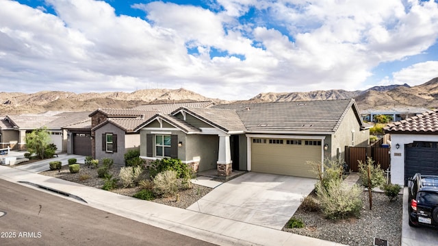 view of front of home with a mountain view, driveway, and stucco siding