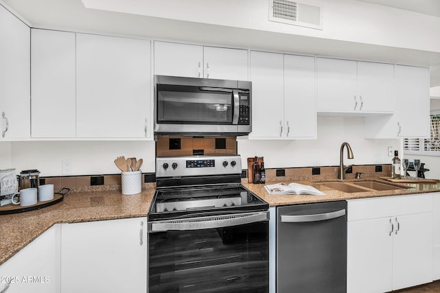 7832 E Via Marina, Scottsdale, AZ 85258 - kitchen with stainless steel appliances, white cabinetry, and dark stone counters