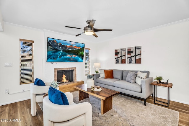 7832 E Via Marina, Scottsdale, AZ 85258 - living room featuring ornamental molding, a fireplace, a ceiling fan, and wood finished floors