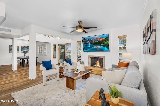 7832 E Via Marina, Scottsdale, AZ 85258 - living room with wood finished floors, a fireplace, ceiling fan, and crown molding
