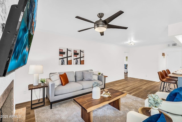 7832 E Via Marina, Scottsdale, AZ 85258 - living area with a brick fireplace, wood finished floors, a ceiling fan, and crown molding
