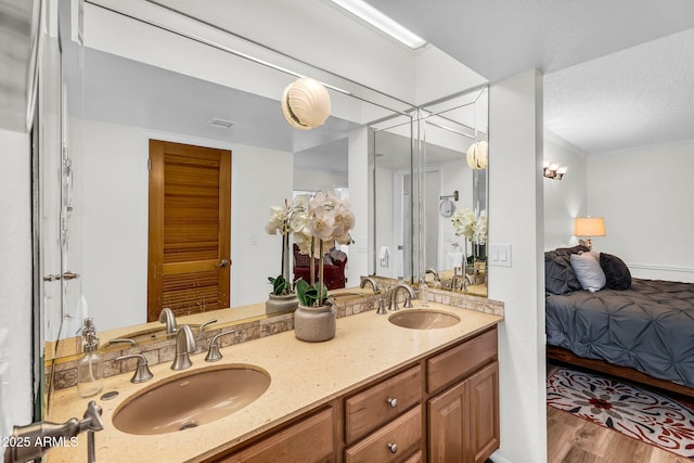 7832 E Via Marina, Scottsdale, AZ 85258 - ensuite bathroom featuring double vanity, wood finished floors, and a textured ceiling