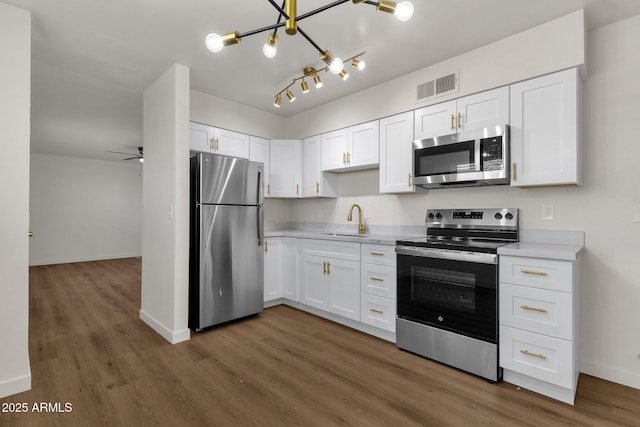 kitchen with white cabinets, ceiling fan, sink, and stainless steel appliances