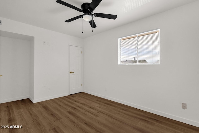 spare room featuring ceiling fan and dark wood-type flooring