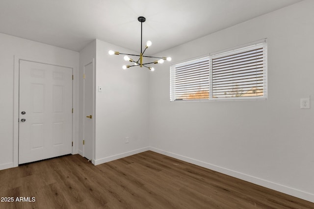 unfurnished dining area featuring dark hardwood / wood-style flooring and an inviting chandelier