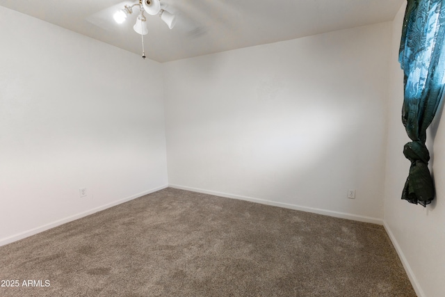 carpeted empty room featuring a ceiling fan and baseboards