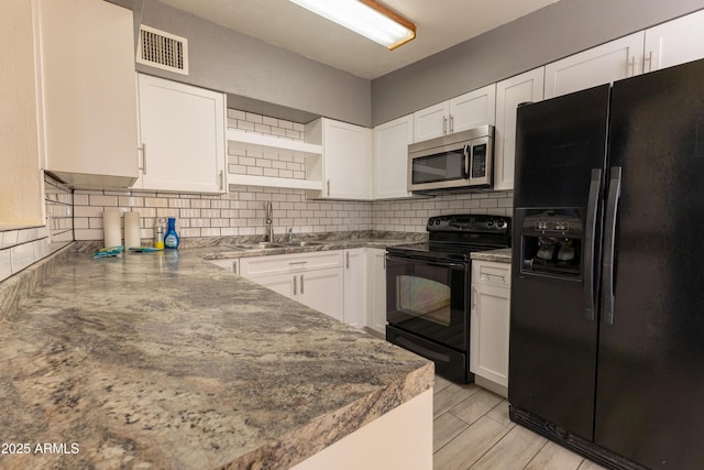 kitchen with open shelves, backsplash, white cabinets, a sink, and black appliances