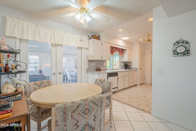 tiled dining area featuring a textured ceiling, sink, and ceiling fan