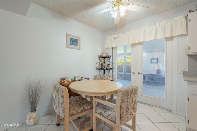 tiled dining space featuring french doors, ceiling fan, and a textured ceiling