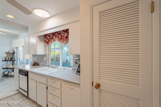 kitchen featuring light tile patterned floors, white cabinetry, a textured ceiling, white dishwasher, and sink