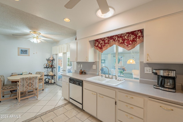 kitchen with dishwasher, sink, light tile patterned floors, white cabinets, and a textured ceiling