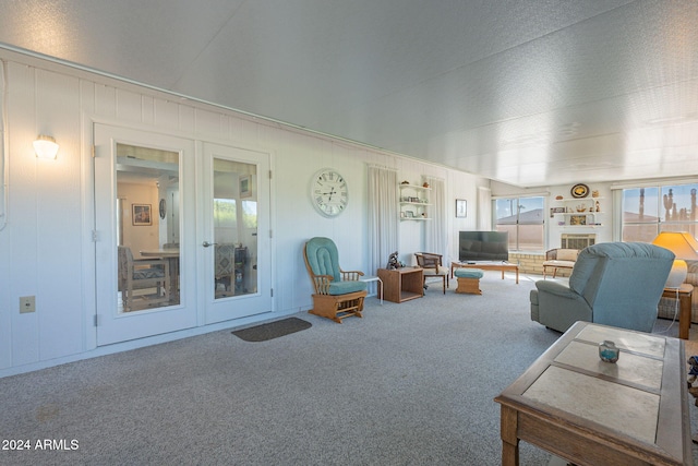 carpeted living room featuring french doors and a textured ceiling