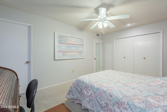 carpeted bedroom with a textured ceiling, a closet, and ceiling fan