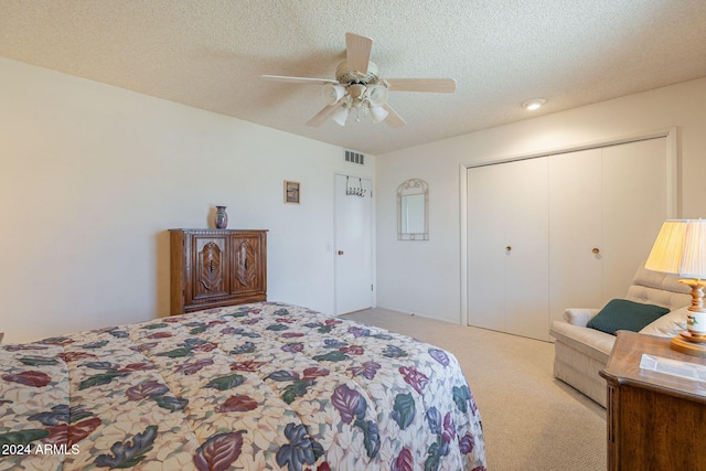 bedroom with light carpet, a closet, a textured ceiling, and ceiling fan