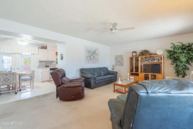 carpeted living room with a textured ceiling and ceiling fan