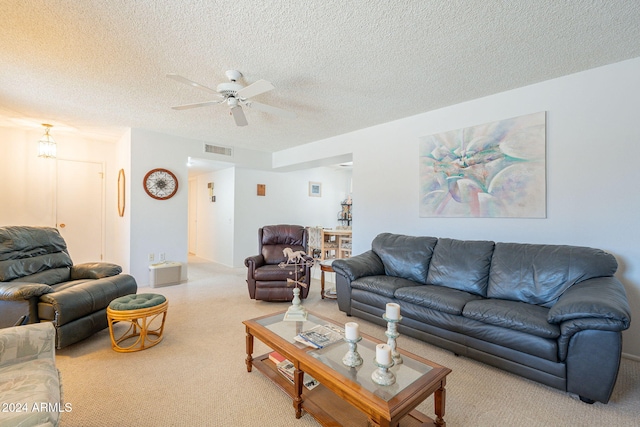 living room with a textured ceiling, carpet floors, and ceiling fan