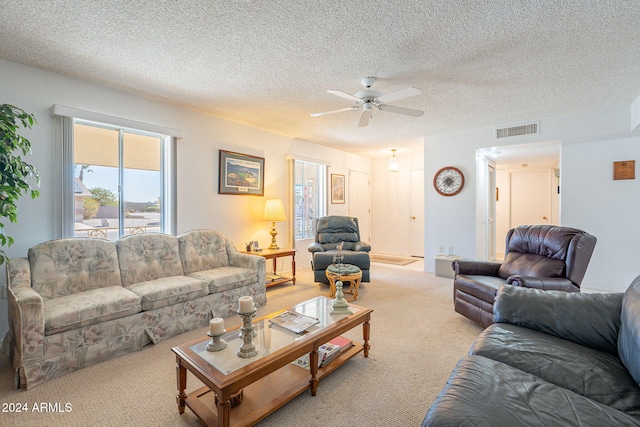 carpeted living room featuring a textured ceiling and ceiling fan