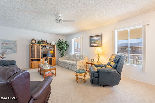 living room featuring carpet floors, a textured ceiling, and ceiling fan