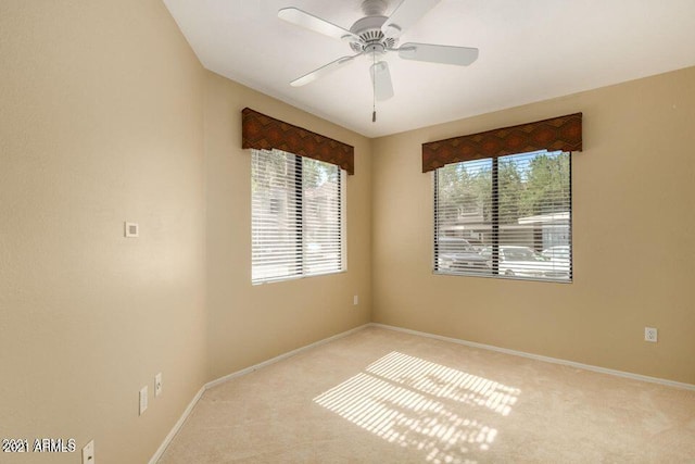 carpeted empty room with baseboards and ceiling fan