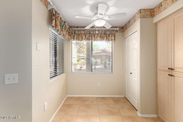 interior space featuring baseboards and light tile patterned flooring