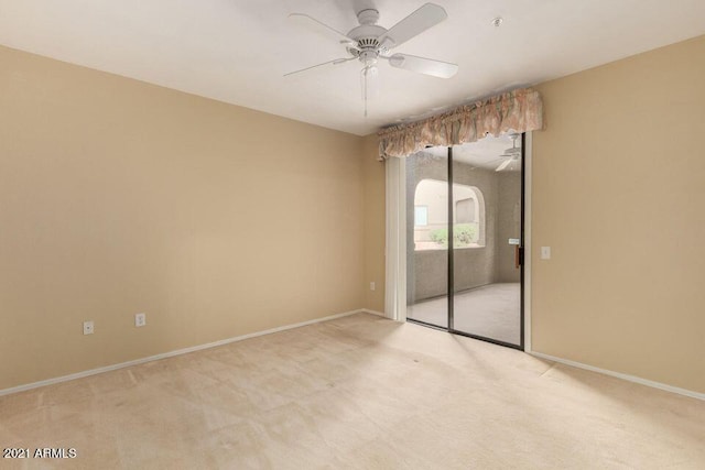 unfurnished room featuring baseboards, light colored carpet, and a ceiling fan