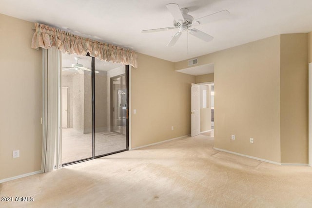 carpeted empty room featuring visible vents, baseboards, and a ceiling fan