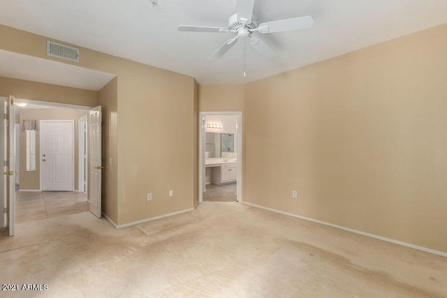 unfurnished bedroom with ensuite bath, light colored carpet, visible vents, and baseboards