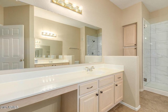 bathroom featuring vanity, a shower stall, toilet, and baseboards