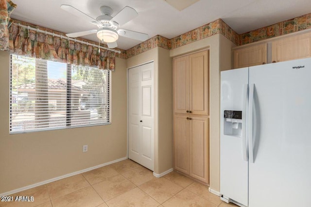 kitchen with light tile patterned floors, ceiling fan, baseboards, and white fridge with ice dispenser