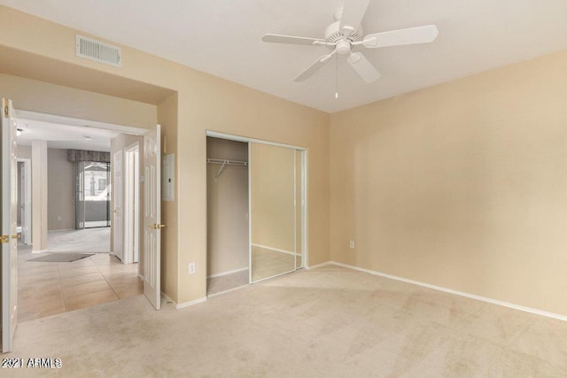 unfurnished bedroom featuring tile patterned flooring, visible vents, baseboards, carpet floors, and a closet