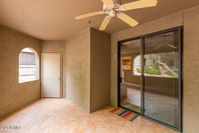 view of exterior entry featuring a ceiling fan