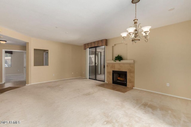 unfurnished living room with light colored carpet, a tile fireplace, and baseboards