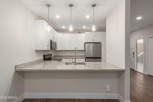 kitchen with recessed lighting, a sink, a peninsula, and stainless steel appliances