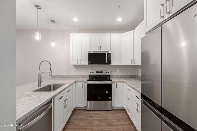kitchen with a sink, stainless steel appliances, and white cabinetry