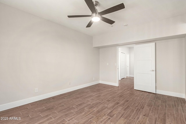 empty room with baseboards, ceiling fan, and wood finished floors