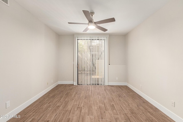 empty room with visible vents, a ceiling fan, light wood finished floors, and baseboards