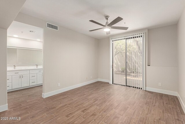 unfurnished room featuring baseboards, visible vents, ceiling fan, and light wood-type flooring