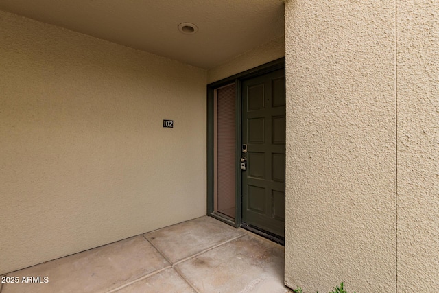 view of exterior entry featuring stucco siding