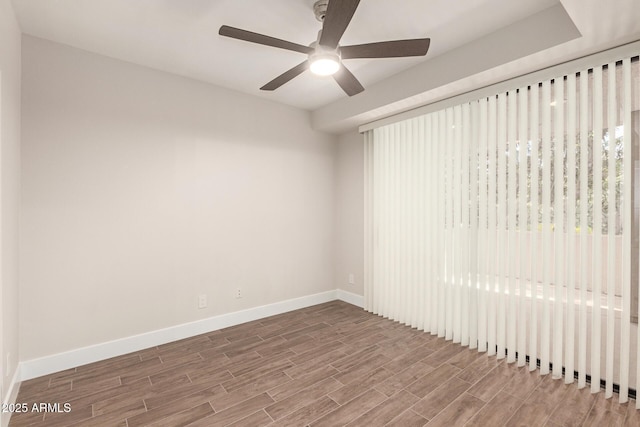 empty room with baseboards, ceiling fan, and wood finished floors