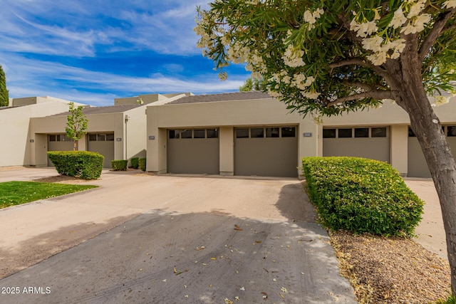 view of front of property featuring an attached garage, stucco siding, and concrete driveway