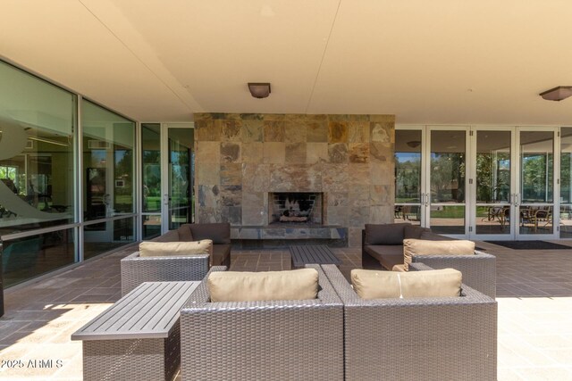 view of patio / terrace with french doors and an outdoor living space with a fireplace