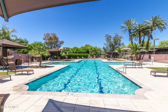community pool with fence and a patio