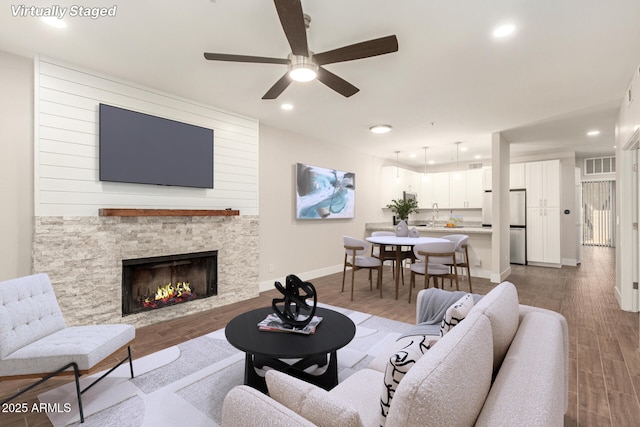 living room with ceiling fan, recessed lighting, baseboards, wood finished floors, and visible vents