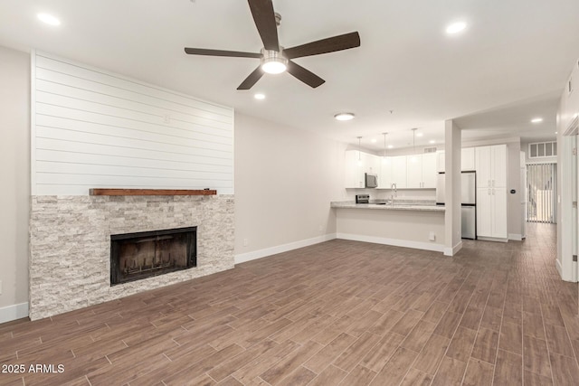 unfurnished living room with dark wood-style flooring, ceiling fan, recessed lighting, baseboards, and visible vents