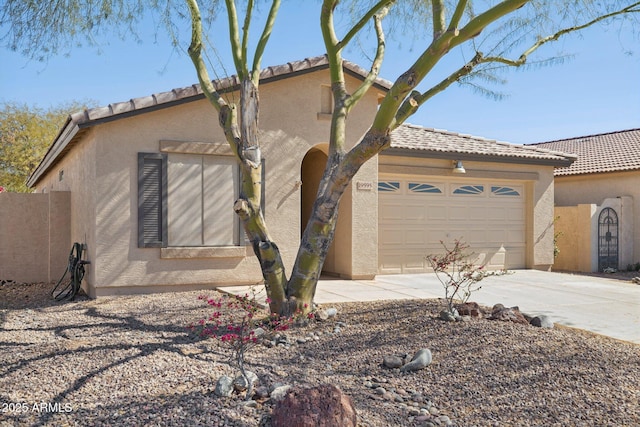 mediterranean / spanish house with a garage, driveway, and stucco siding